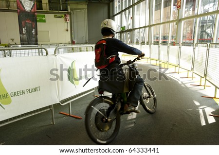 MILAN - NOVEMBER 3: Visitor testing an electric bicycle at EICMA, 68th International Bicycle and motorcycle Exhibition in Milan Fair, November 3, 2010
