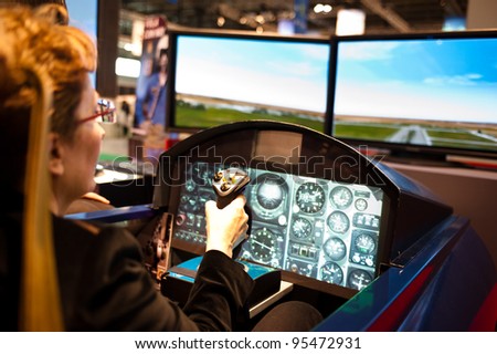 MILAN, ITALY - FEBRUARY 17: A visitor plays on a flight simulator at BIT International Tourism Exchange on february 17, 2012 in Milan, Italy.