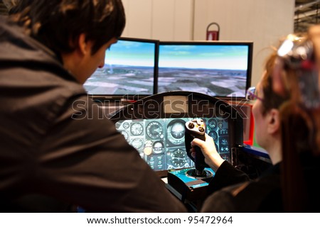 MILAN, ITALY - FEBRUARY 17: A visitor tries a flight simulator at BIT International Tourism Exchange on february 17, 2012 in Milan, Italy.