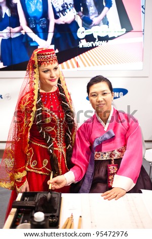 MILAN, ITALY - FEBRUARY 17: Azerbaijan dancer and korean woman at BIT International Tourism Exchange on february 17, 2012 in Milan, Italy.