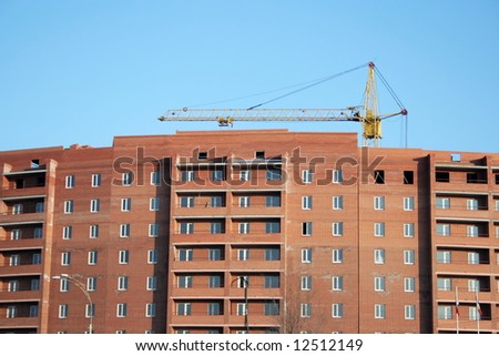 Lifting crane on building of the new house on sky background
