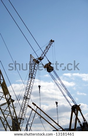 Construction. Silhouettes of the cranes on the sky background.