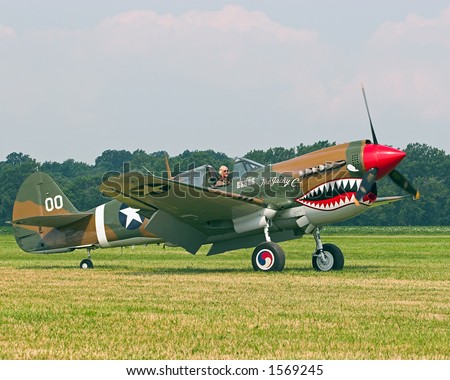 Color DSLR picture of a replica military Curtis P-40 Warhawk fighter plane taxing for takeoff. Known as Flying Tigers they served in Pacific fighting Japanes in WWII.  Horizontal; copy space for text