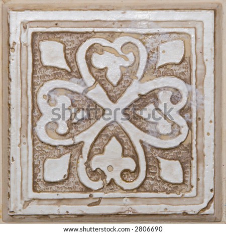 Color DSLR picture of a square, white, off white, beige or tan decorative ceramic tile with flower pattern. Good for design, background and details.