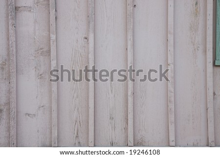 Painted, weathered wood siding on the wall of a building