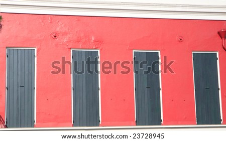 Red building with green shutters, in horizontal orientation