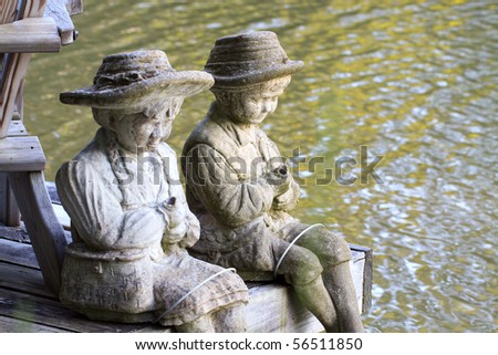 Color DSLR statues of a little boy and girl sitting by the Erie Canal, New York. Figurines are in horizontal orientation with copy space for text.