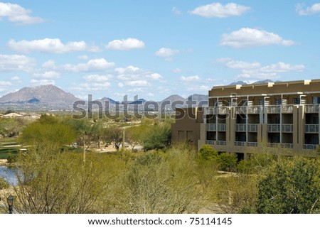 Hotel resort in the Arizona desert desert with a blue sky and mountains in the background; with copy space for text