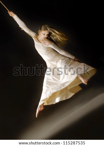 attractive young dancing woman  on rope in white dress