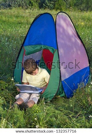 boy with laptop in tent sunny day