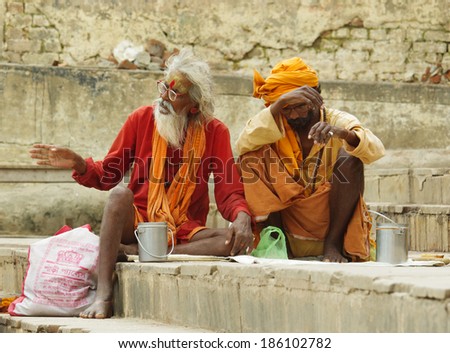 VARANASI, INDIA - OCT 1: An unidentified sadhu with traditional painted face and body, sits at the ghat along the Ganges on October 1, 2013 in Varanasi, India.