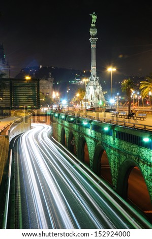 Streaks of traffic lights in Barcelona with the Columbus monument at the background.
