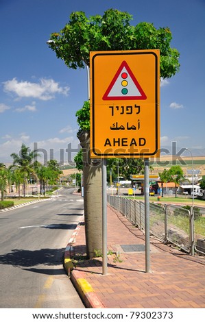 Signboard warning about the traffic light ahead. Written in Hebrew, English and Arabic. Tiberius city. Israel.