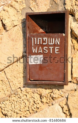 Refuse bin on some old wall in Jaffa with hebrew caption.