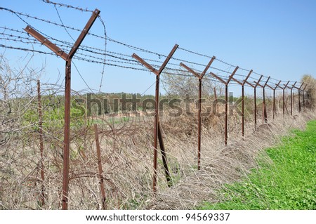 A fence of barbed wire enclosing dangerous slope at Golan Heights. Israel.