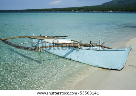 outrigger canoe on the white sand beaches of camiguin island in the philippines