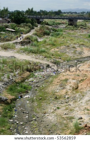 stock photo : three men walk dusty path through polluted river valley in the ... stock photo : three men walk dusty path through polluted river valley in the ...