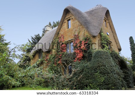 traditional style cotswalds thatched roof stone cottage in oxfordshire england