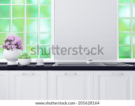 Kitchenware on the black marble worktop in front of big light window. White and black kitchen design.
