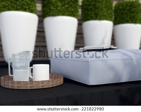 Close-up outdoor patio seating area. Big pillow with book and tray on the wooden step.