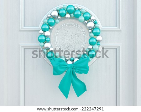 Classic home door decorated with blue balls wreath for the holiday.