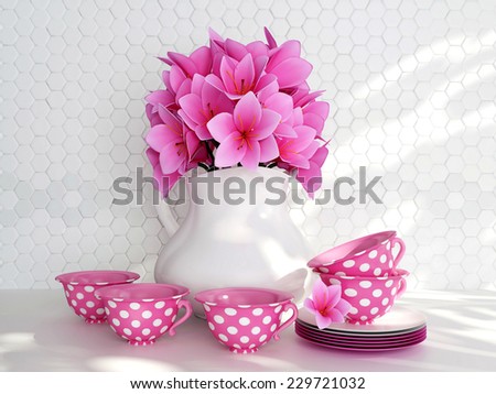 Kitchen still life. Ceramic vase with pink flowers and tea cups on the table in front of white till wall.