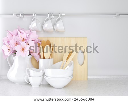 Wooden and ceramic utensils with flowers on the white marble worktop.