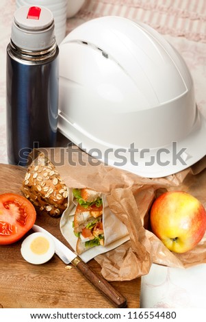 Construction worker\'s helmet and sandwich lunch bag