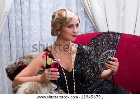 Vintage twenties lady with cocktail and lace fan