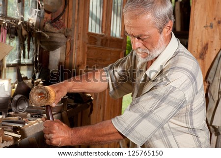 Closeup of a skilled carpenter working with wood in an old shed