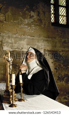 Altar of a medieval 17th century church and a young nun in prayer Altar of a medieval 17th century church and a young nun in prayer