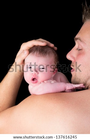Cute father holding his 11 days old newborn baby in his arms