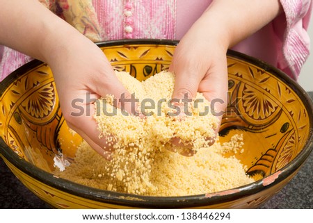 Traditional Moroccan immigrant woman in Europe cooking couscous during Ramadan