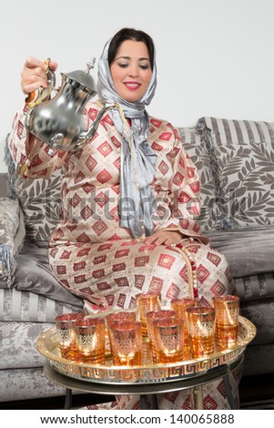Moroccan immigrant woman in Europe pouring tea for her guests