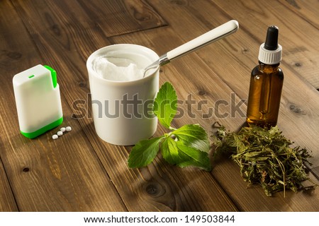 White tablets and green leaves of natural sweetener stevia
