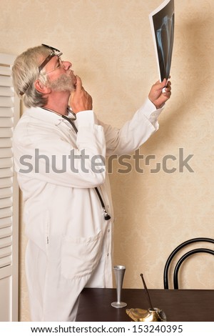 Vintage doctor examining an x-ray and looking worried