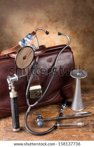 Doctor\'S Bag And Antique Medical Instruments Such As Stethoscope, Reflex Hammer And Head Mirror