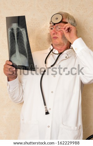 Vintage doctor examining an x-ray in his clinic