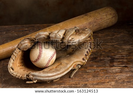 Old baseball bat with ball and weathered glove