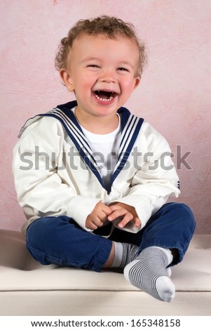 Cute little victorian toddler boy dressed in vintage sailor costume