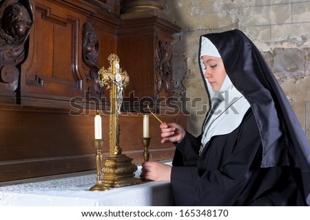 Medieval 17th century altar with a nun lighting the candles