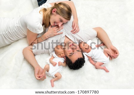 Happy family portrait of two young parents with their newborn twins