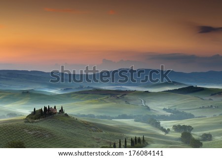 Villa near Pienza in the Tuscan hills on a foggy day at dawn