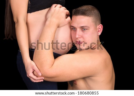 Smiling father holding his wife's pregnant belly in his hands