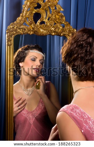 Stunning vintage 1920s woman looking in an antique mirror