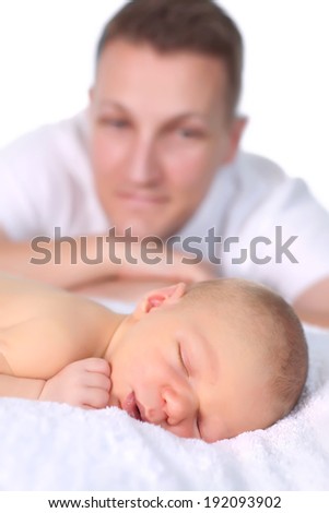 Proud out of focus father admiring his sleeping newborn baby of 16 days old