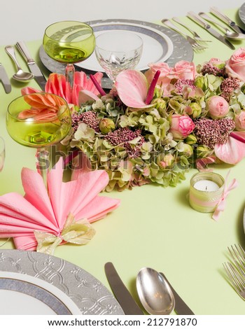 Beautiful two-tone flower arrangement in soft pink and green on a christmas dinner table