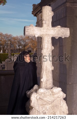 Victorian woman praying at All Saints in a graveyard