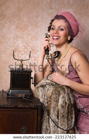 Stunning vintage 1920s woman talking on an antique telephone