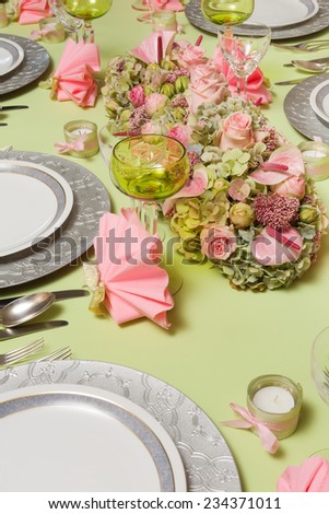 Beautiful twotone flower arrangement in soft pink and green on a christmas dinner table